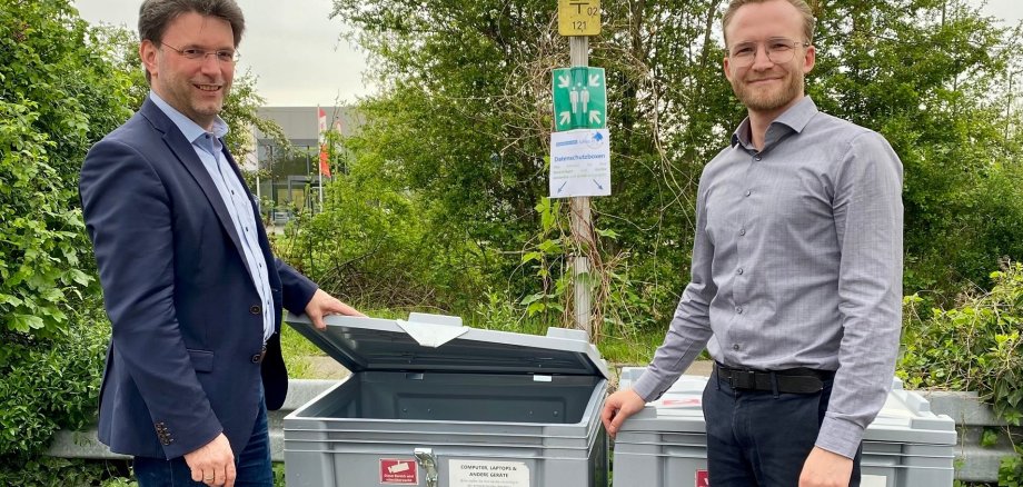Bürgermeister Glogger und Matthias Juchum vor zwei gesicherten Boxen für die Abgabe von Elektronik.
