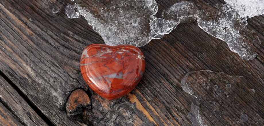 Rotes Herz auf Holzbank im Wintermonat