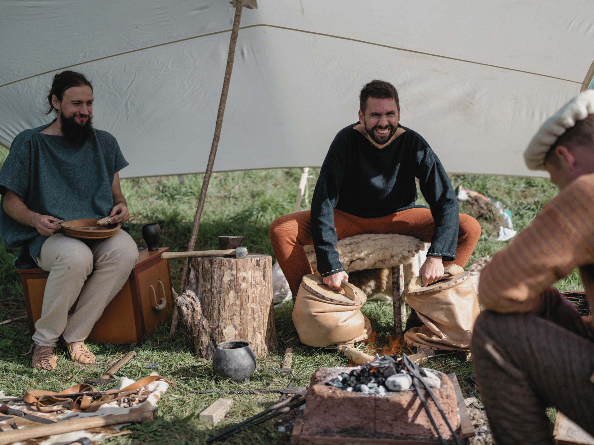 3 Männer sitzen zusammen am Lagerfeuer