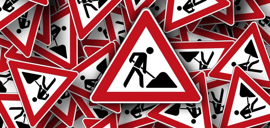 Straßenschilder mit Achtung Baustelle Symbol