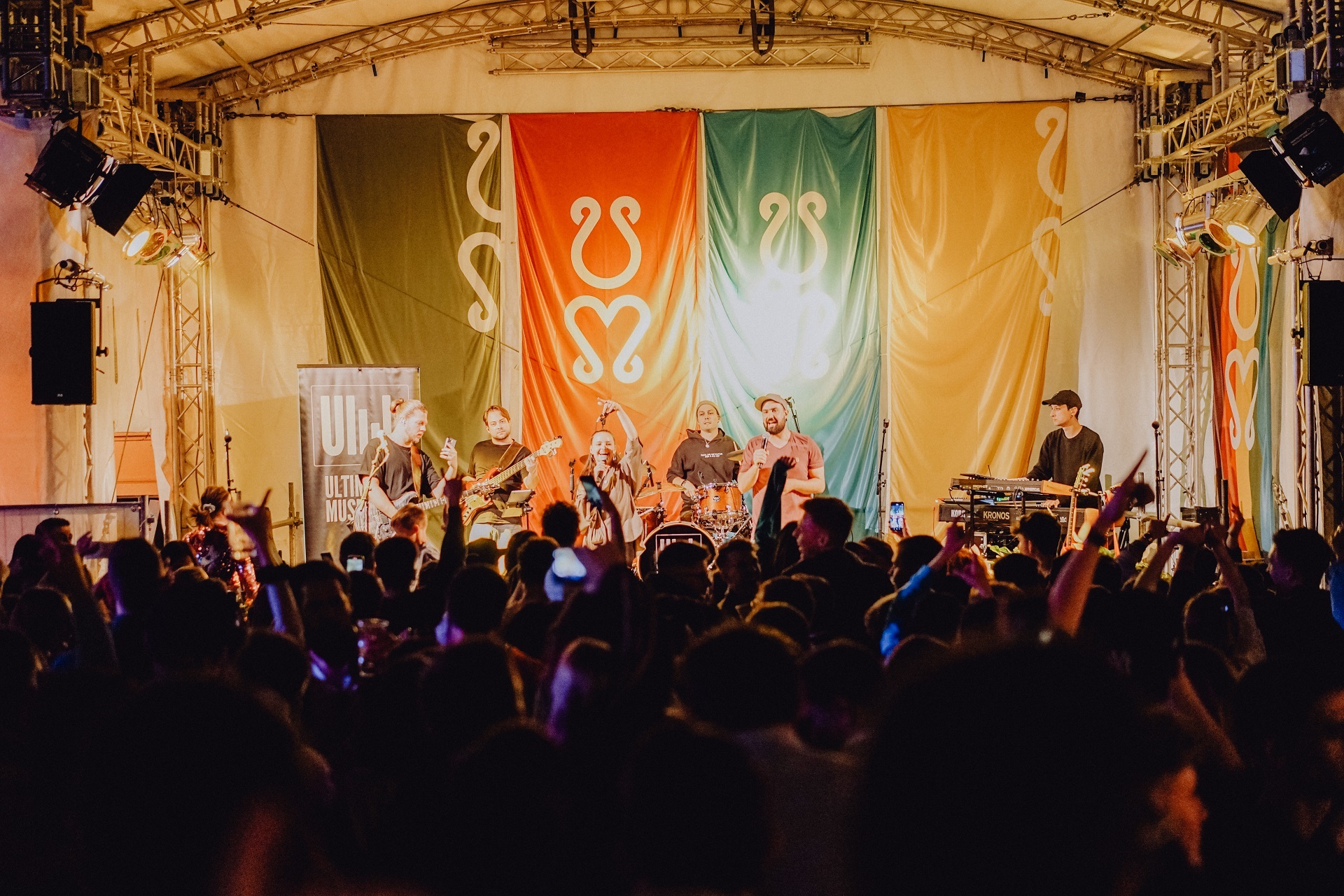 Am Abend spielt eine Band auf der beleuchteten Stadtfestbühne. Vor der Bühne sind viele Zuhörer zu erkennen.