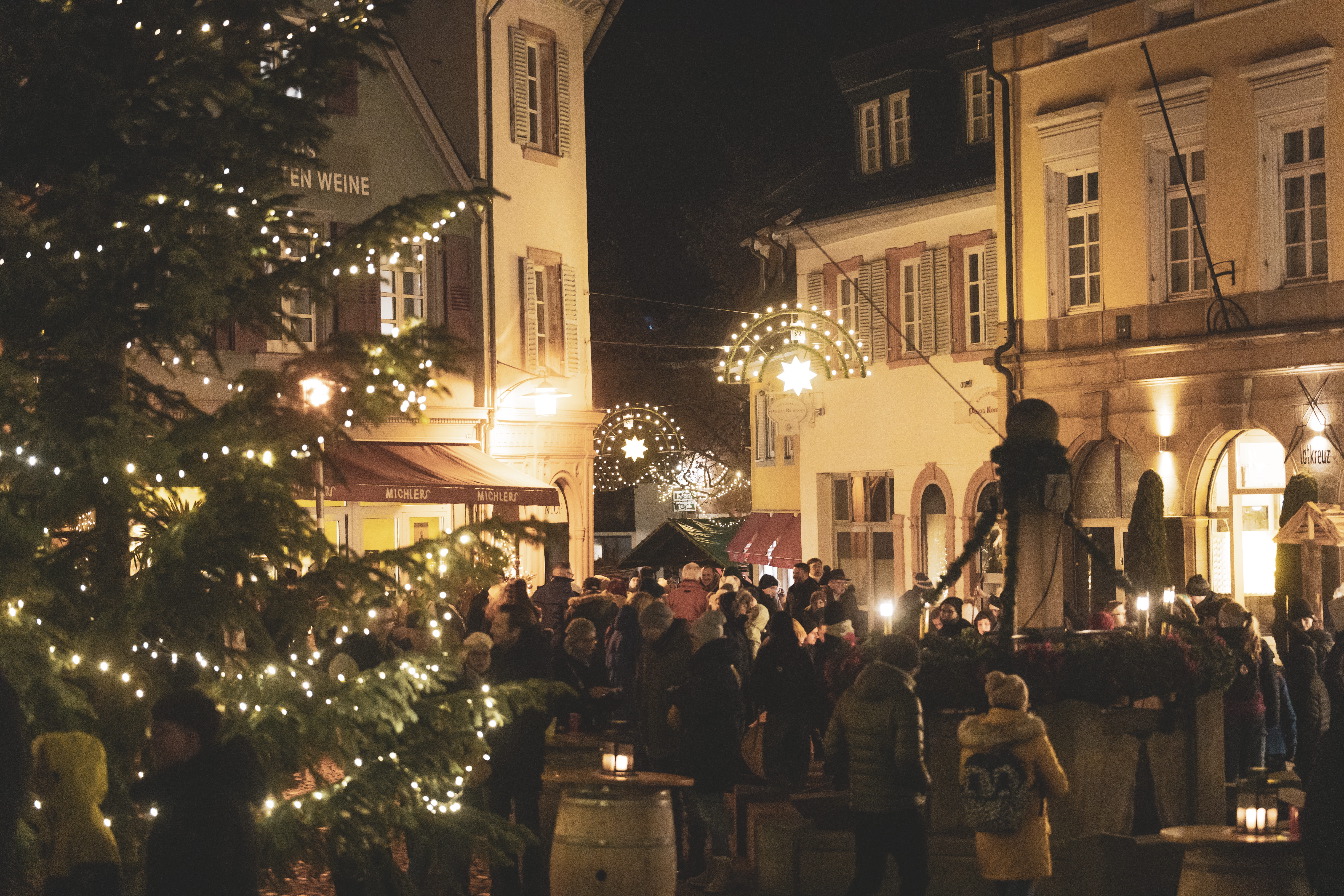 Auf dem weihnachtlich geschmückten Römerplatz in der Innenstadt versammelt sich eine große Gruppe an Adventsfreunden.