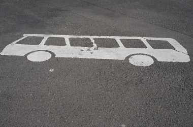 Ein gemaltes Bussymbol auf einem betonierten Parkplatz.