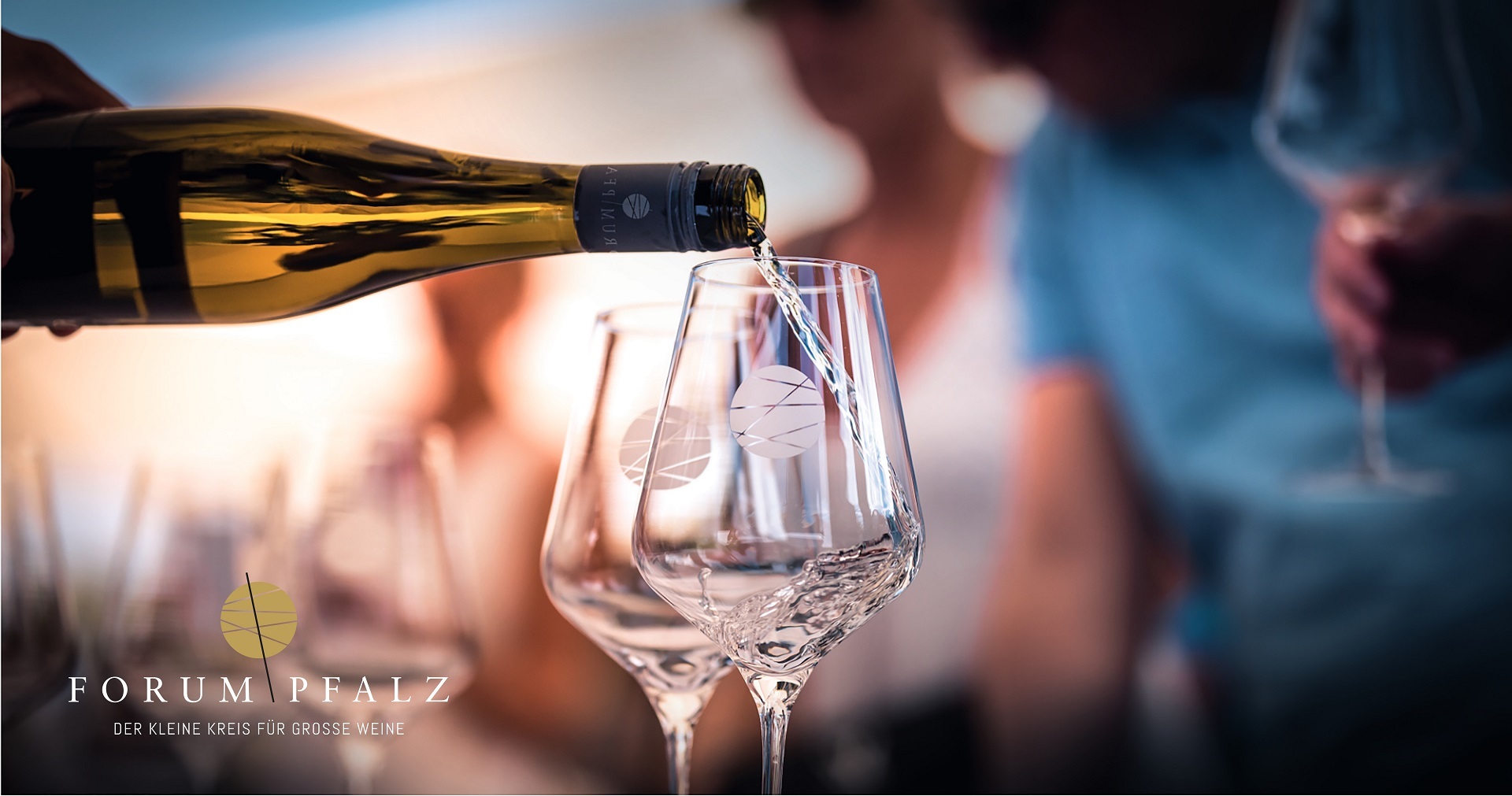 Zwei Weingläser mit dem Logo vom Forum Pfalz werden mit einem Weißwein befüllt. Der Hintergrund ist verschwommen.
