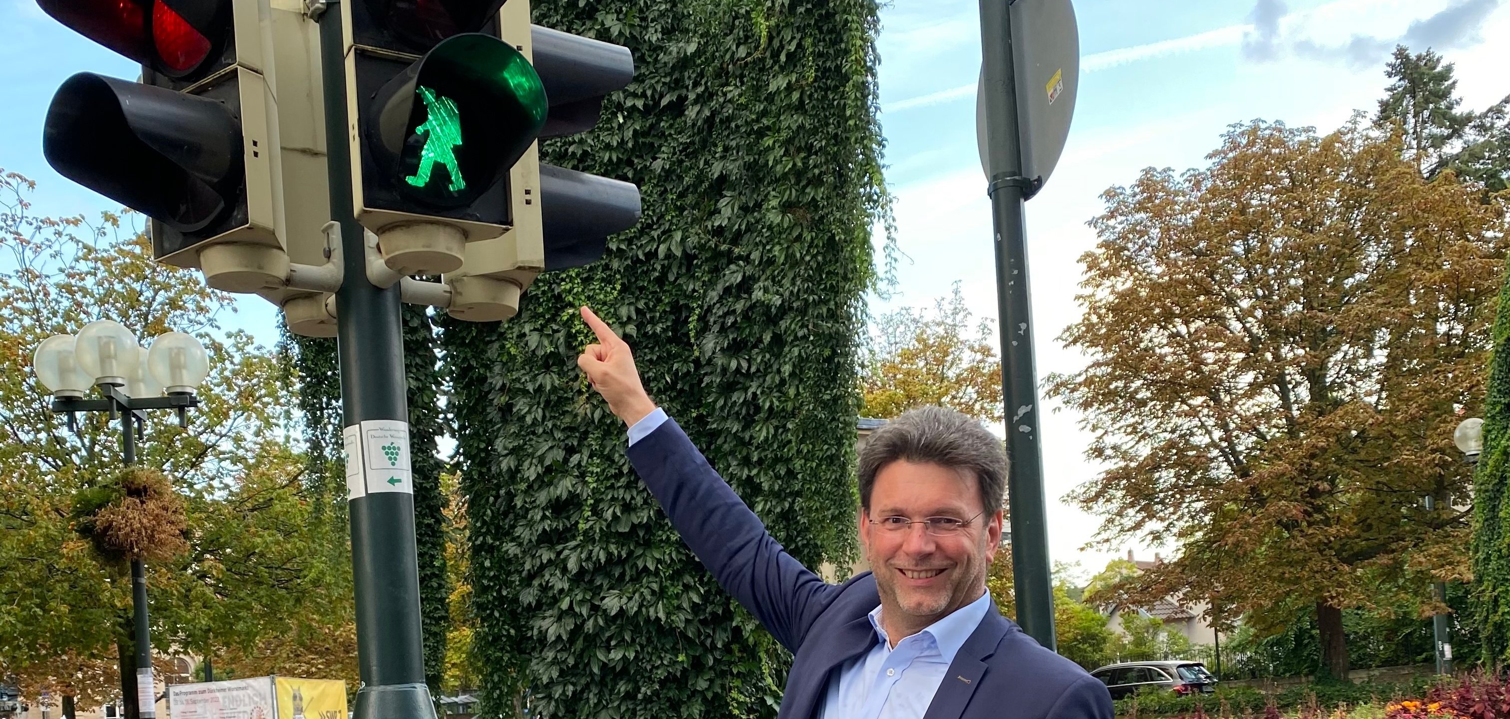 Bürgermeister Glogger zeigt auf Ampel mit Symbol des Winzermännchens