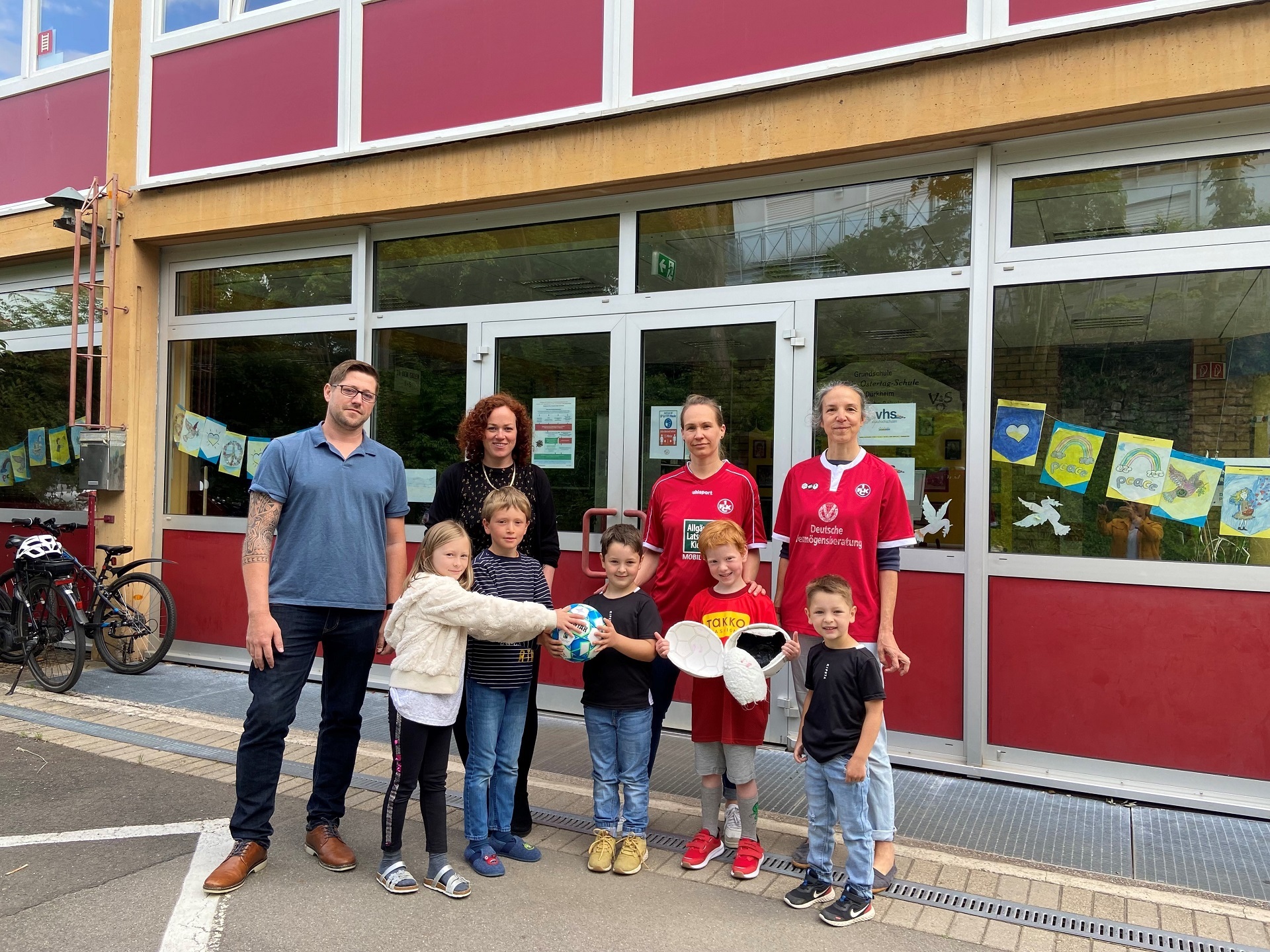 Kindergartenkinder mit Erziehern vor der Schule. Sie sind unterwegs in einer fairen Mission für die Schärfung des Bewusstseins für Nachhaltigkeit.