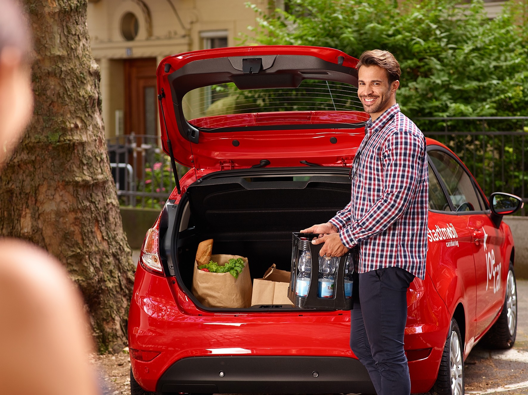 Mann vor Stadtmobil Auto
