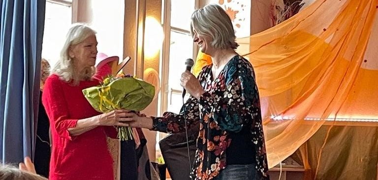 Frau bekommt Blumen überreicht