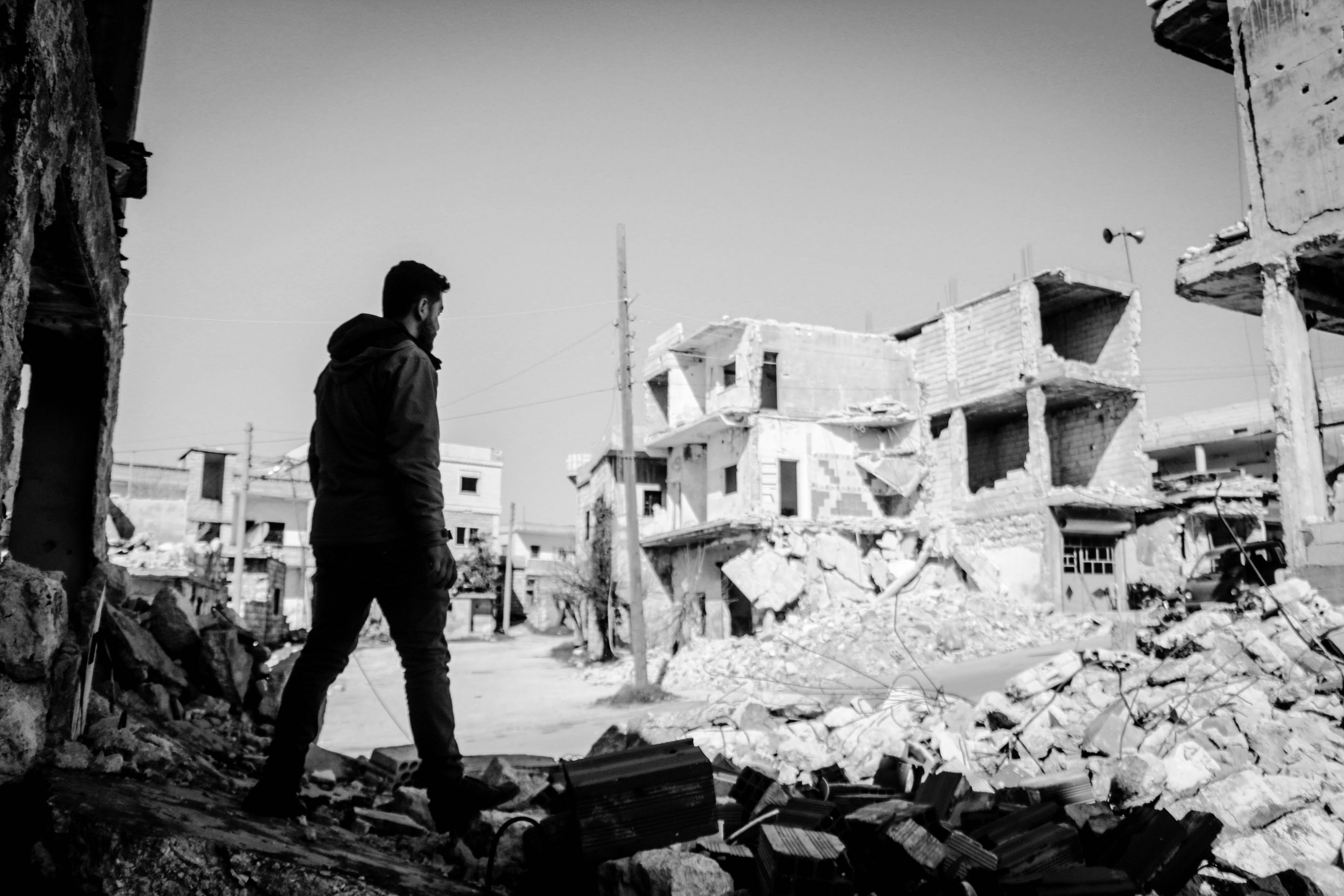 Mann steht vor Trümmern nach Bombenangriff