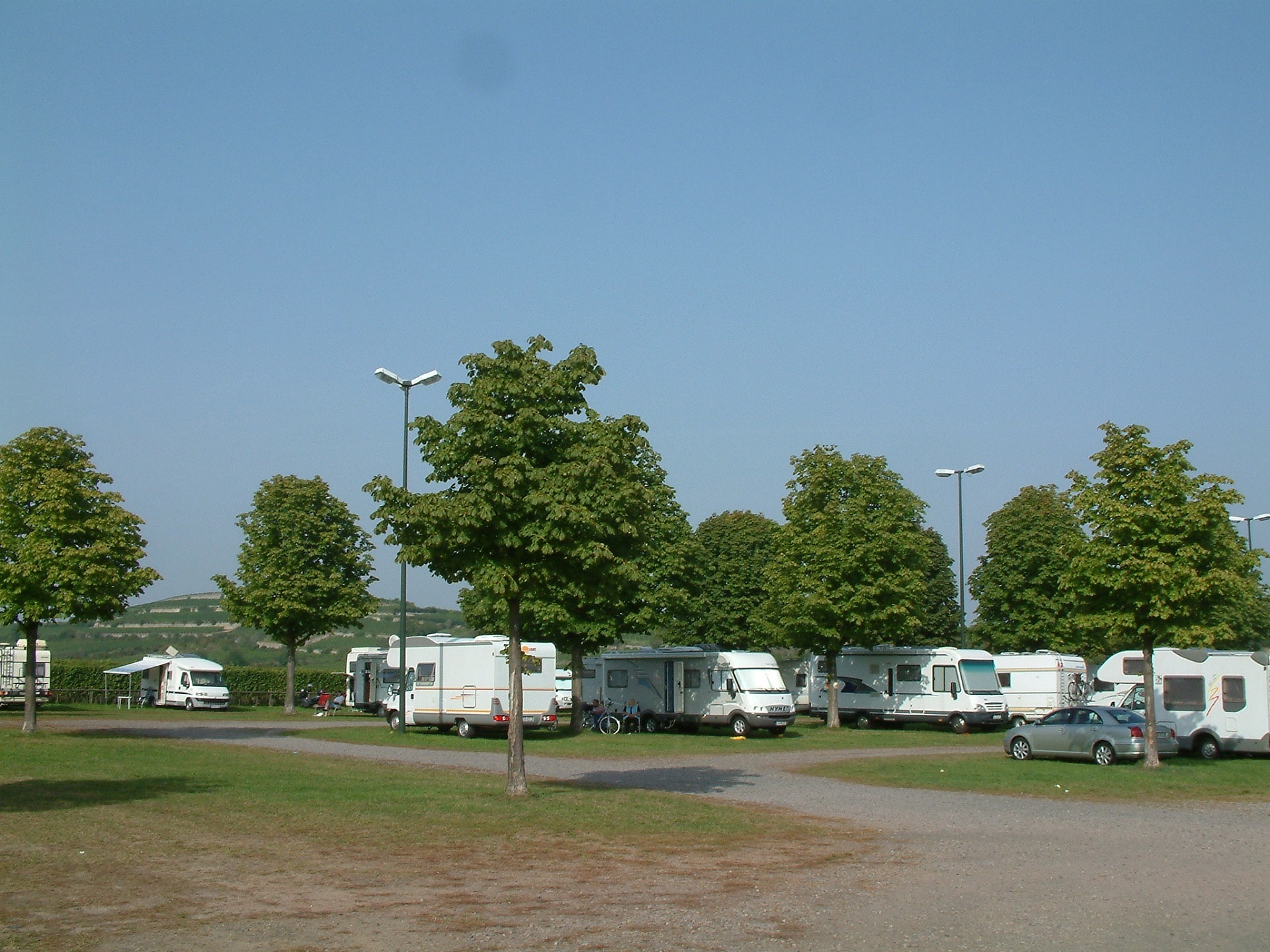 Wohnmobilstellplatz in der Silz Der Wohnmobilstellplatz in der Silz, mit einigen Weißen Wohnmobilen, grünen Bäumen und Straßenlaternen.