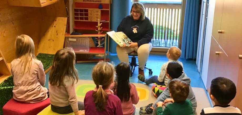 Vorlesetag 2025 Angela Strobel sitz mit einer Runde Kindern mit einem Buch in der Hand