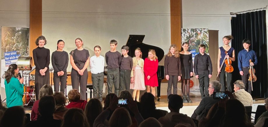 78. VR Bank-Schlarb-Konzert: Nachwuchsmusikerinnen und -musiker begeistern im Dürkheimer Haus Gruppenfoto Teilnehmerinnen und Teilnehmer des Konzertes stehen gemeinsam auf der Bühne