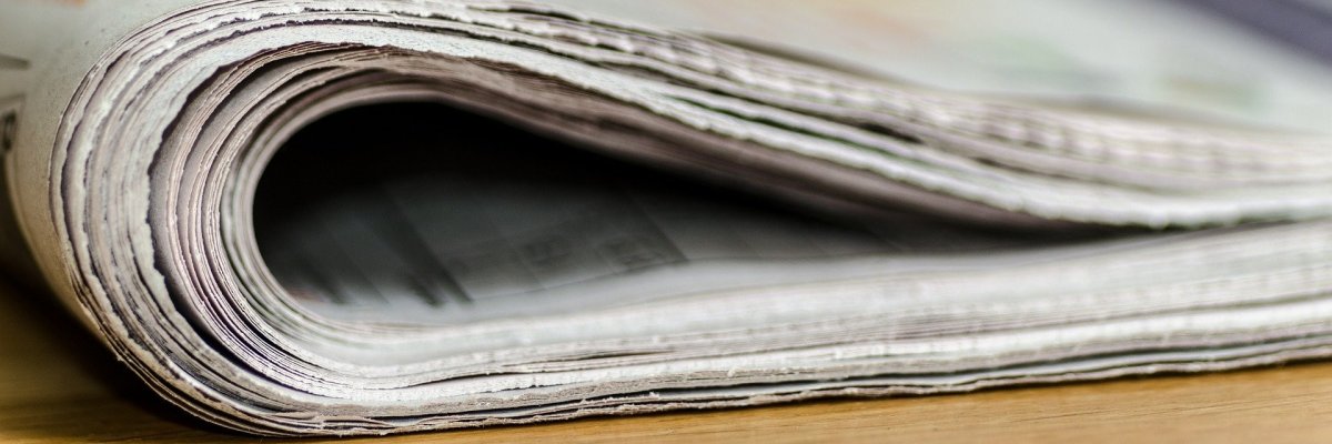 auf einem Tisch liegt eine zusammengefaltete Zeitung
