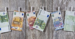 Geldscheine hängen mit Wäscheklammern an Leine